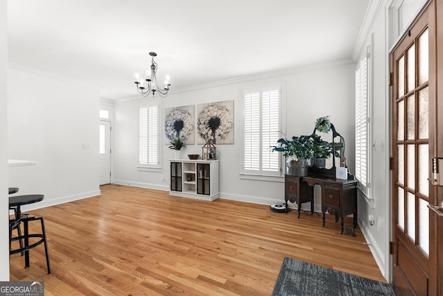 entryway featuring light wood-style flooring, a notable chandelier, a wealth of natural light, and ornamental molding