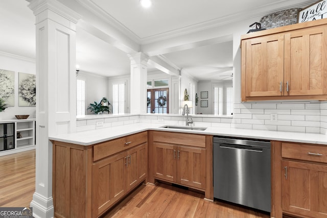 kitchen with a sink, crown molding, light countertops, dishwasher, and ornate columns