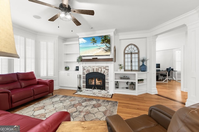 living area featuring a fireplace, built in features, wood finished floors, and ornamental molding