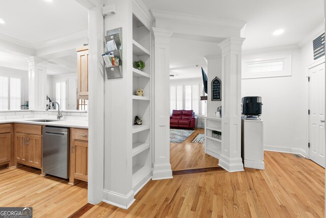 interior space with a sink, light wood-style floors, dishwasher, and ornate columns