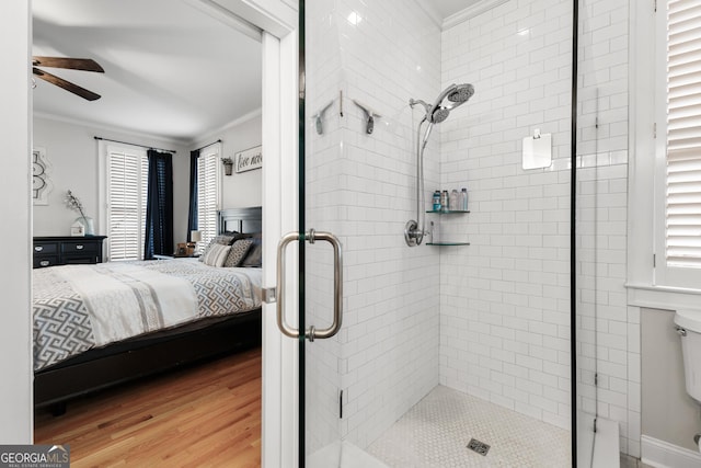 ensuite bathroom featuring crown molding, wood finished floors, a stall shower, and ensuite bathroom