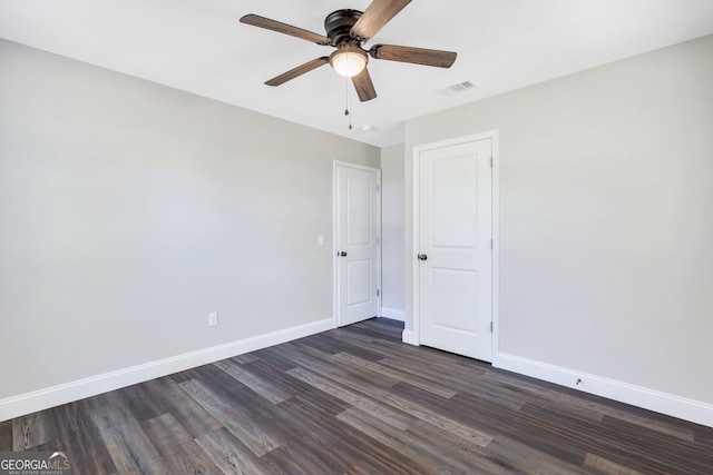 unfurnished bedroom featuring visible vents, dark wood-style floors, baseboards, and ceiling fan