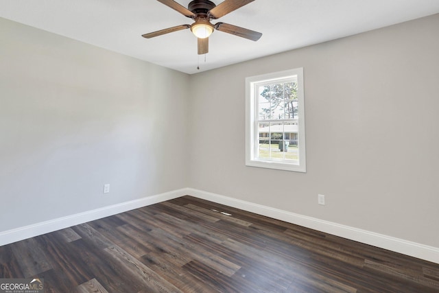 spare room featuring ceiling fan, baseboards, and dark wood finished floors