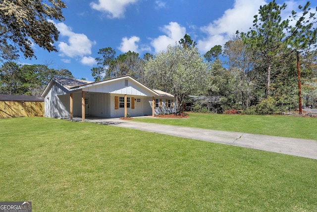 view of front of home featuring brick siding, an attached carport, driveway, and a front yard