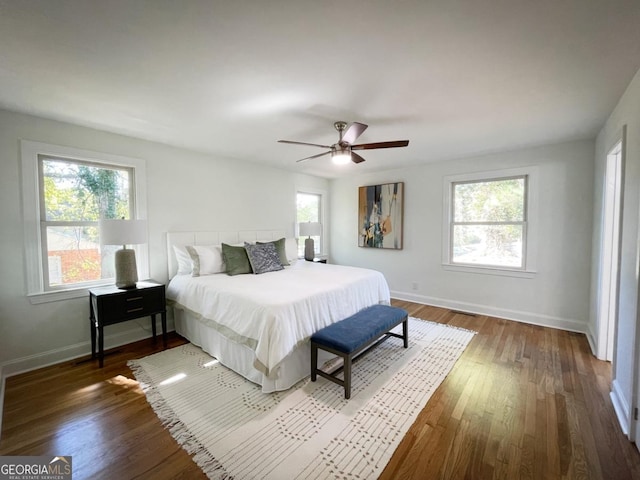 bedroom featuring ceiling fan, baseboards, and wood finished floors