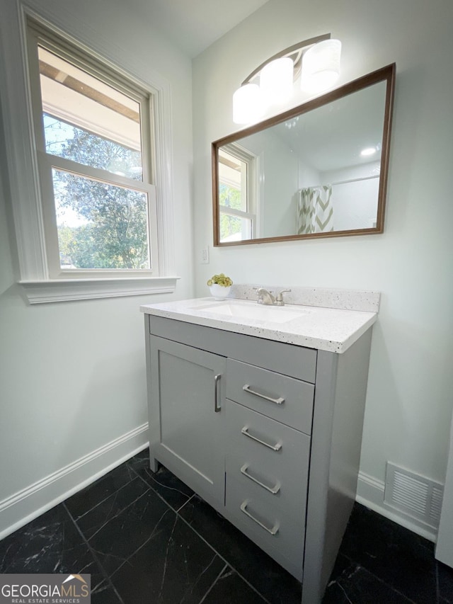 bathroom with visible vents, baseboards, marble finish floor, and vanity