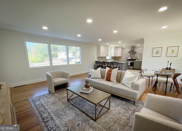 living room with wood finished floors, recessed lighting, visible vents, and baseboards