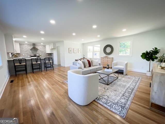 living room featuring recessed lighting, light wood-style flooring, and baseboards