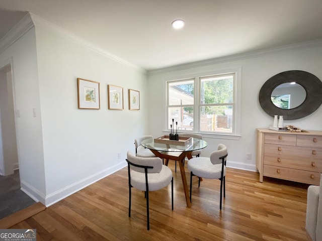 dining room with wood finished floors, baseboards, and ornamental molding