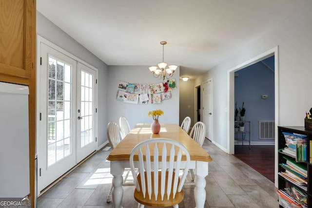 dining space featuring an inviting chandelier, french doors, visible vents, and baseboards