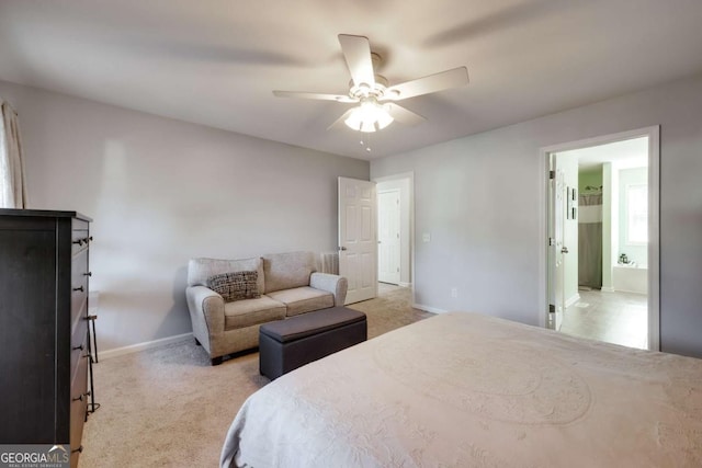 bedroom with baseboards, light colored carpet, ensuite bath, and a ceiling fan