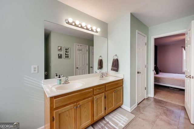 ensuite bathroom featuring a sink, ensuite bathroom, double vanity, and tile patterned flooring