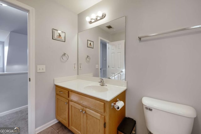 half bath with vanity, baseboards, visible vents, tile patterned floors, and toilet