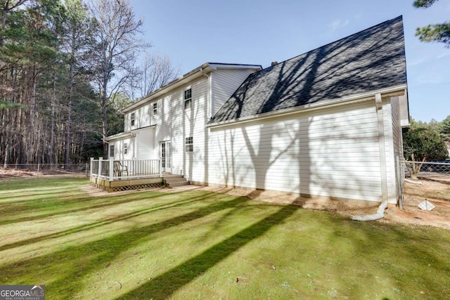 back of property with a lawn, fence, driveway, and a wooden deck