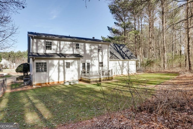 rear view of house with french doors, a lawn, a deck, and fence