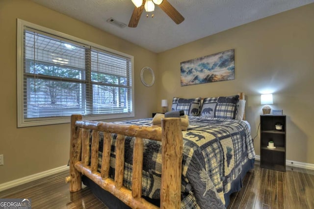 bedroom featuring visible vents, a ceiling fan, a textured ceiling, wood finished floors, and baseboards