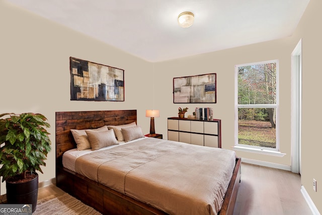 bedroom featuring baseboards and wood finished floors