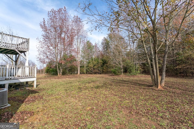 view of yard featuring central AC and a deck