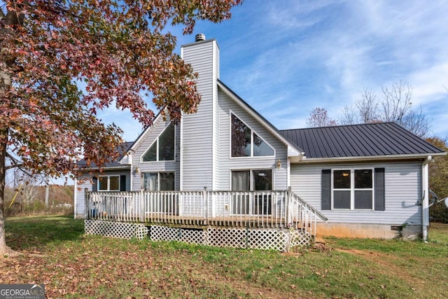 back of house featuring a deck, a yard, metal roof, and a chimney