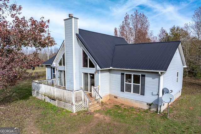 view of front facade with a front lawn, a wooden deck, a chimney, metal roof, and crawl space