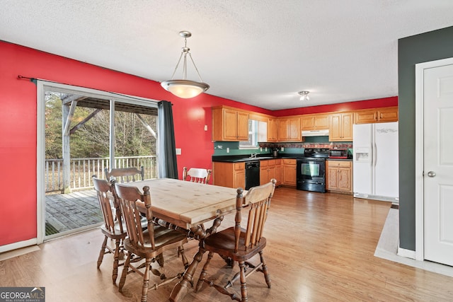 dining space featuring baseboards, a textured ceiling, and light wood-style floors