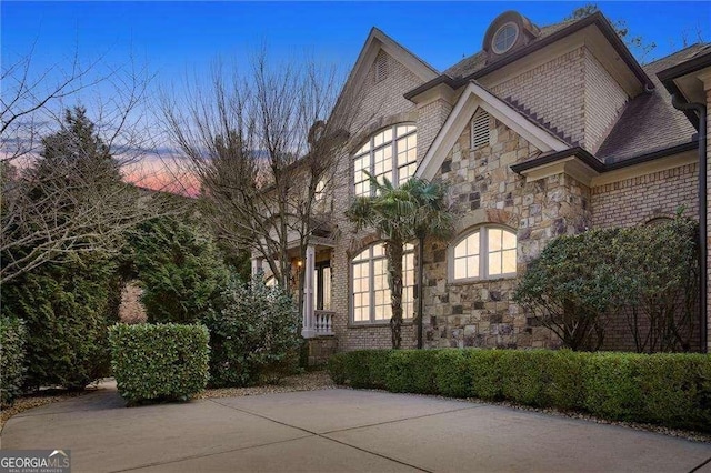 view of property exterior with stone siding and brick siding