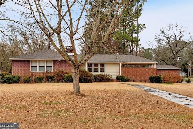 ranch-style house featuring brick siding and a front yard