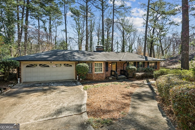 ranch-style home featuring a garage, brick siding, driveway, and a chimney