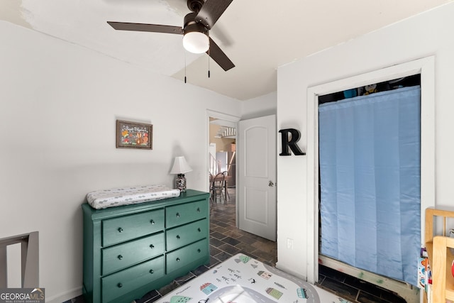 bedroom with stone finish flooring and ceiling fan