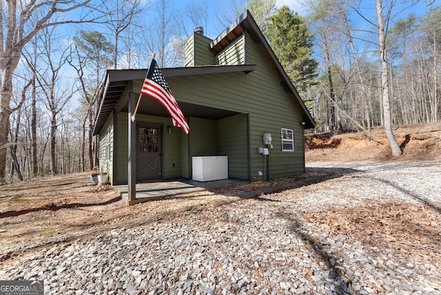 view of front of house with driveway and a chimney