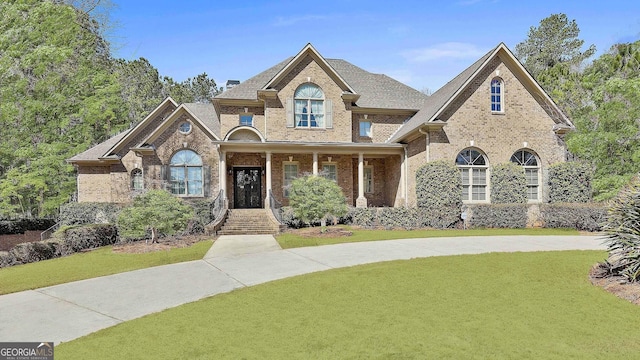 view of front of house featuring brick siding and a front lawn