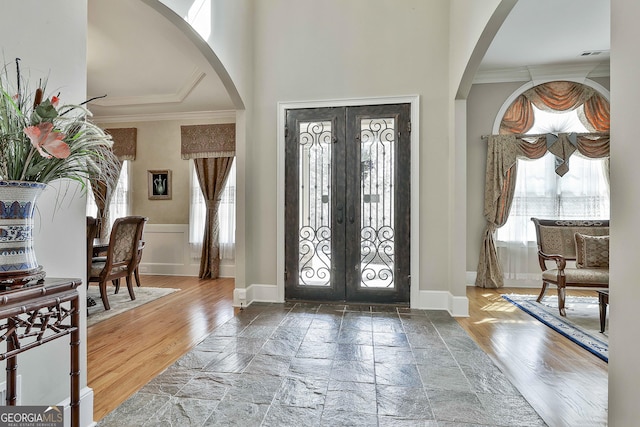 entryway featuring wood finished floors, french doors, baseboards, and ornamental molding