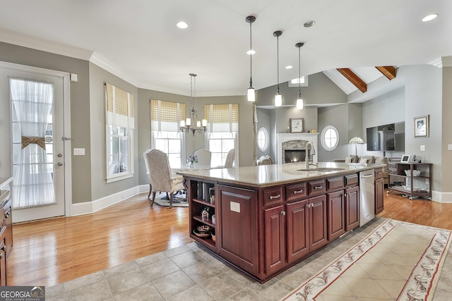 kitchen featuring a stone fireplace, light wood-style flooring, dark brown cabinets, and a sink