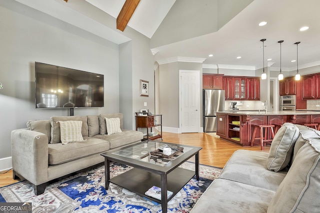 living area with ornamental molding, recessed lighting, arched walkways, light wood-style floors, and baseboards