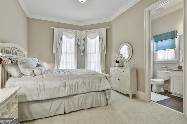 bedroom with carpet flooring, ensuite bath, and ornamental molding