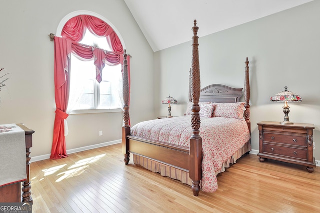 bedroom with baseboards, lofted ceiling, and light wood-style floors