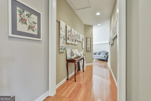 corridor featuring recessed lighting, light wood-type flooring, baseboards, and attic access