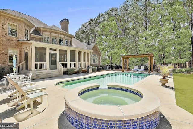 view of pool featuring a pool with connected hot tub, a pergola, a patio, and a sunroom