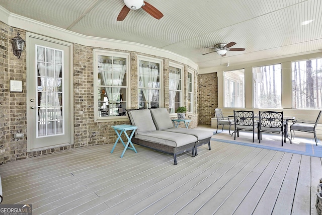 wooden deck featuring outdoor dining area and a ceiling fan