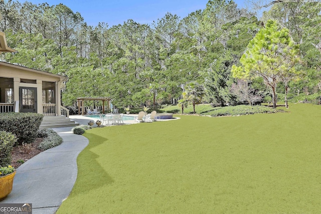 view of yard featuring an outdoor pool, a patio, a pergola, and a sunroom