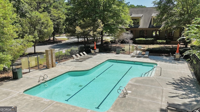 pool with a patio area and fence