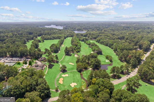 aerial view with a water view, view of golf course, and a wooded view