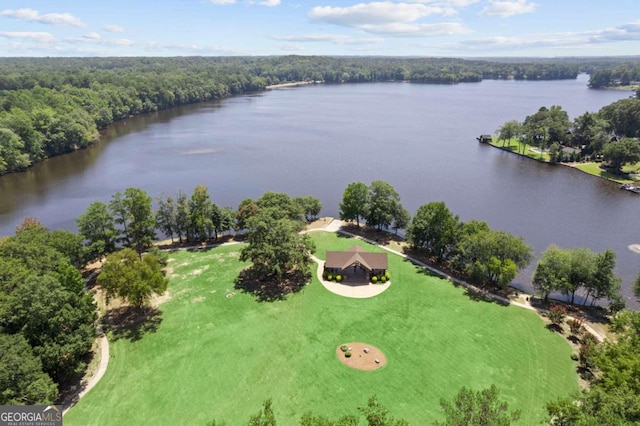 drone / aerial view with a forest view and a water view