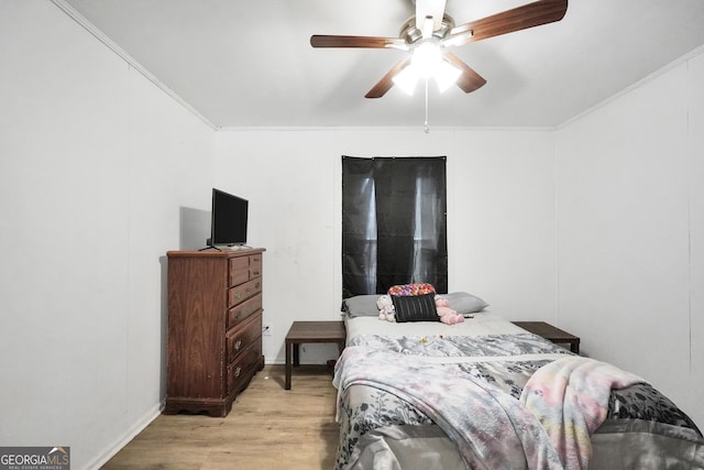 bedroom with ceiling fan, light wood-type flooring, and ornamental molding