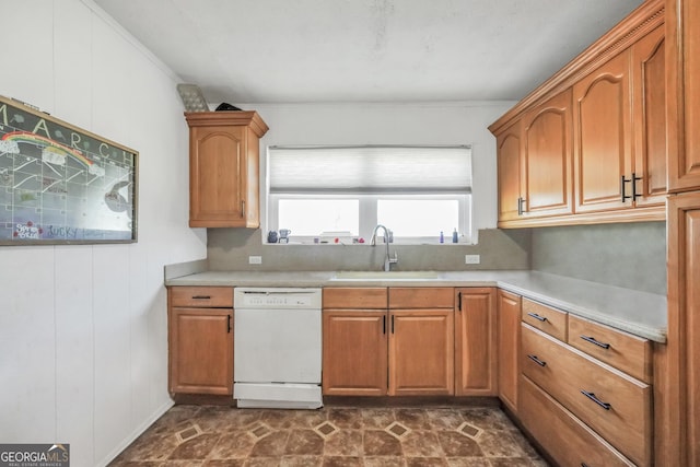 kitchen featuring brown cabinets, dishwasher, light countertops, and a sink