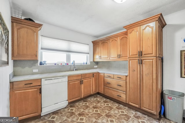 kitchen featuring brown cabinetry, a sink, light countertops, and white dishwasher