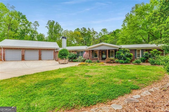 single story home with a front lawn, brick siding, a detached garage, and a chimney