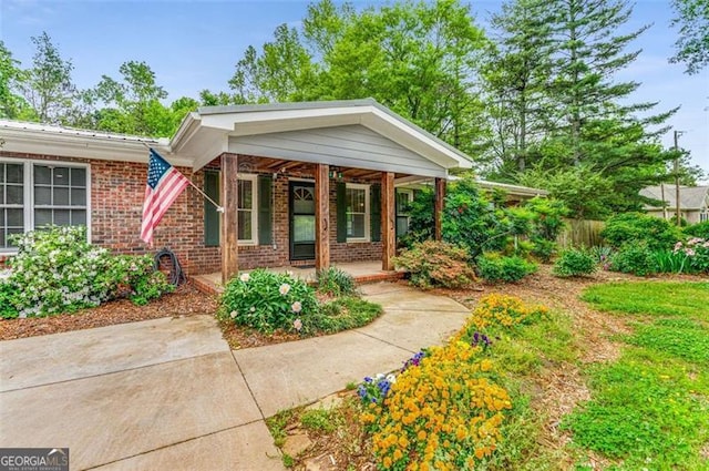 property entrance featuring brick siding and a porch