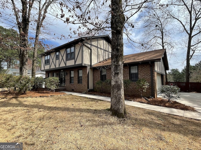 view of front of property with brick siding, concrete driveway, an attached garage, and fence