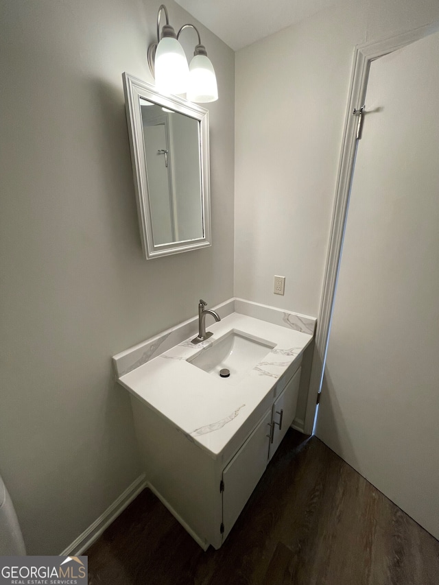 bathroom featuring vanity, baseboards, and wood finished floors